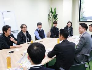 会議室で説明を聞く様子