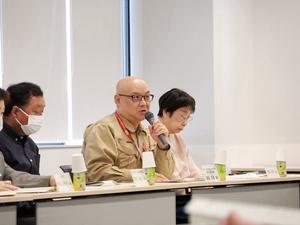 マイクを持って発言する委員