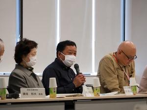 マイクを持って発言する委員