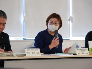 マイクを持って発言する委員