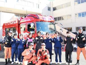 消防車の前で消防署員と記念撮影する中学生たち