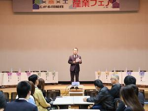 壇上で開会の挨拶をするアポロ工業中村新一社長