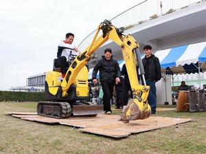 屋外でユンボを操作する市長