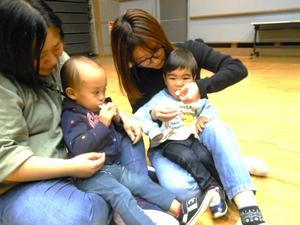 ママの膝に座り、ゲットしたおせんべいを食べる男の子たちの様子