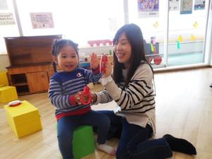 歌にあわせて鈴とタンバリンを鳴らす親子の様子