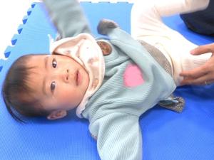 ブルーマットに寝転ぶ、カメラ目線の赤ちゃんの様子