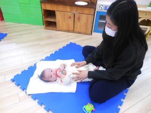 ふれあい遊びを楽しむおもちゃを握った赤ちゃんの様子