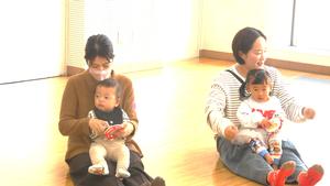 ママのおひざでタンバリンを鳴らす子ども達の様子