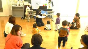 講師の先生が絵本を読んでいるのを見ている親子の様子