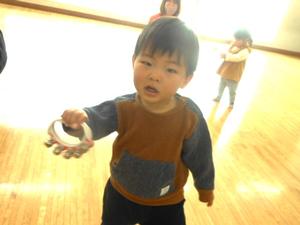 鈴を片手に持ちカメラに向ける男の子の様子