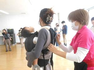 抱っこひもの正しい付け方の指導をしている講師の先生の様子