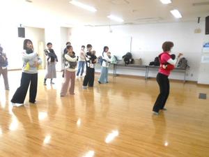 赤ちゃんを抱っこしてベビーダンスの指導を受けている様子