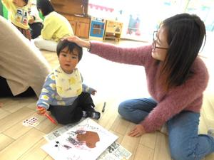 工作でお絵描きをしている我が子の頭をなでるママの様子