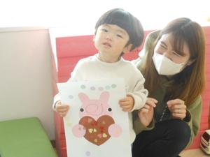 完成した作品を得意げに見せてくれる男の子とそれを見て笑うママの様子