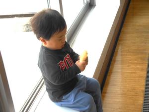 窓際に座りおもちゃで遊んでいる男の子の様子