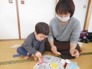 工作でのり付けをしている親子の様子