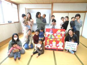 ゲームで完成したひな壇を囲み集合写真を撮る参加者の様子