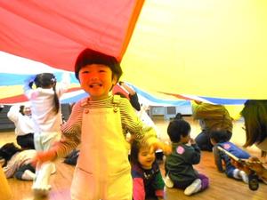 バルーンの下に入っている子ども達と、笑顔を見せる男の子の様子