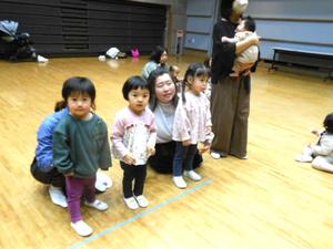おせんべい競争でスタート地点に並ぶ3人の子どもの様子