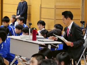 発表を聞きながら資料にメモをする市長