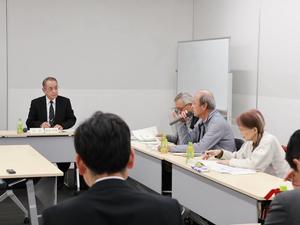 マイクを持って意見を述べる委員