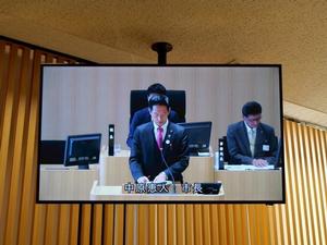 議場に登壇する市長を映したモニター
