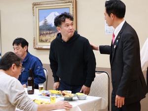 忘年会で消防団の方々と談笑する市長