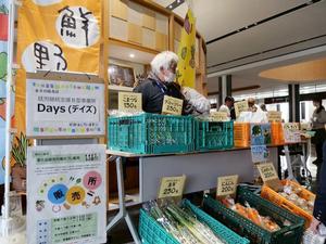市役所入り口の地場産野菜や市特産品を販売するブース