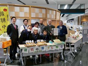 市役所入り口の地場産野菜や市特産品を販売するブースで市長と皆さんとの記念撮影