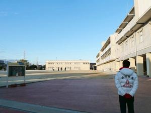 グラウンド整備をする先生たちを遠めに見る市長