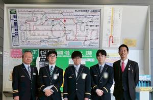 券売機の前で実習生の皆さんと木村駅長と市長との集合写真