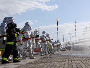 一斉放水する消防団