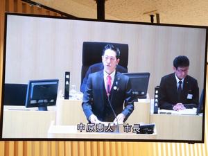 モニターに映る施政方針演説をする市長