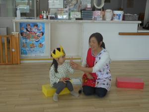 3歳のお友達が職員と一緒に指で3を示そうとしている様子