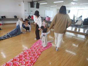 本物の大きなこいのぼり飾りの上を歩いたり中をくぐったりしている様子