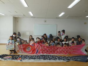 大きな鯉のぼりを持って参加者全員で集合写真
