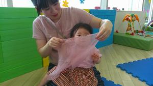 ふれあい遊びで使うやわらかい布の感触を楽しむ子ども