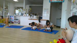 職員の手本に合わせ子供とふれあうママたちの様子