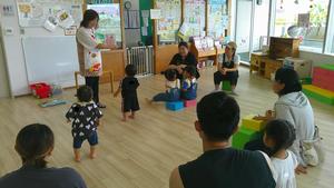 絵本に近づいたり、友達と並んで座って読み聞かせを聞いている子どもたちの様子