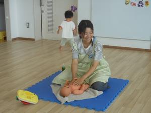 赤ちゃん人形を使用してオイルマッサージの仕方を説明する様子
