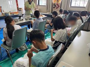 子どもが牛乳パックを裂いている様子