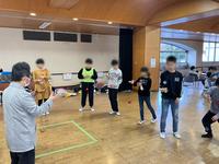 大人が子どもにけん玉を教えている様子