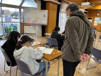 子どもが勉強しているのを、大人が見守る様子