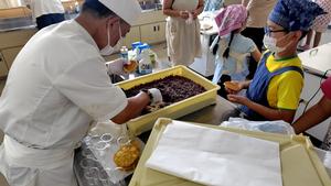 子どもたちがどら焼きにあんこを入れてもらっている様子
