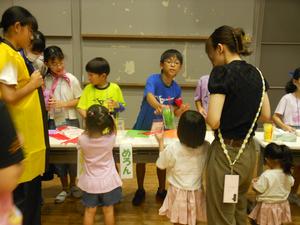 ジュース屋さんでお兄さんお姉さんからジュースを受け取る様子