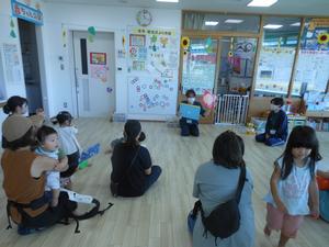 大学生のお兄さんに紙芝居を読んでもらっている様子