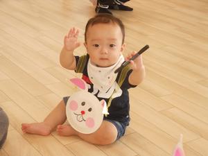 うさぎのポーチを下げてポーズをとる赤ちゃんの写真