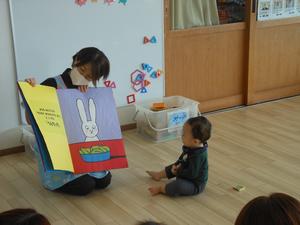 大型の手作り絵本の読み聞かせを見ている男の子の写真