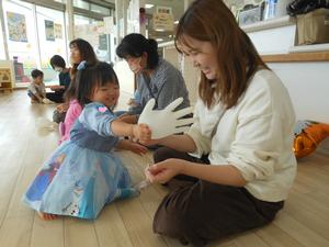 空気を入れたゴム手袋を嬉しそうに触る女の子の写真