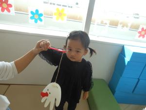 緊張しながら完成したゴム手袋おばけを見せる女の子の写真